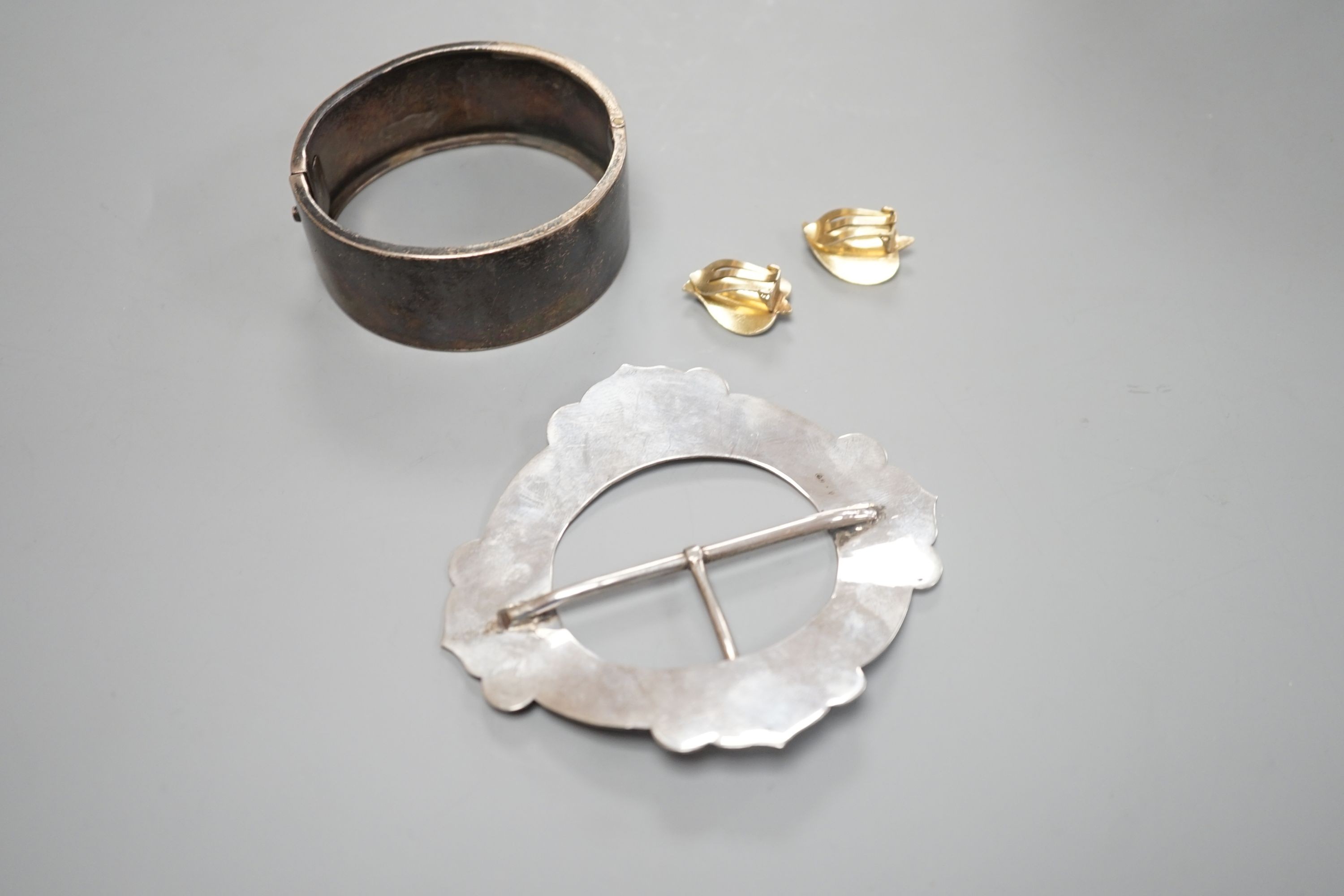 A late Victorian engraved silver hinged bangle, a white metal and niello buckle and a pair of mid 20th century Norwegian gilt 925 and enamel leaf ear clips by Hans Myhre.
